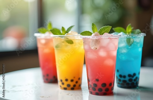 Obraz na płótnie Four colorful bubble tea drinks in plastic cups with mint leaves. Variety of flavors, ice cubes, and tapioca pearls create refreshing beverages for summer. Perfect for cafes restaurants bars menu. w salonie