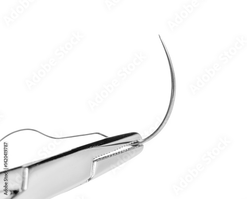 Close-up of a surgical needle threaded with suture. Sharp point and fine thread against a white background.