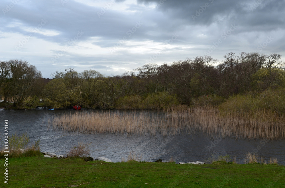 Fototapeta premium Dark Clouds Over a River with Boats Moored