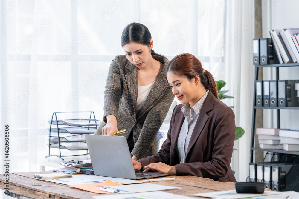 Two Businesswomen Collaborating on Laptop in Office Two Businesswomen Collaborating on Laptop in Office