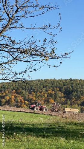 The Tractor is Working in a Beautiful, Scenic Autumn Landscape, Enhancing the Surroundings