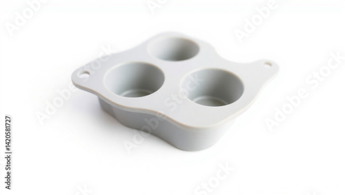 Close up of a gray silicone mold with three circular cavities on a white background in a studio shot created with generated ai