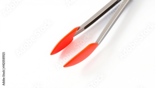 Close up of stainless steel kitchen tongs with red silicone tips on a white background surface created with generated ai