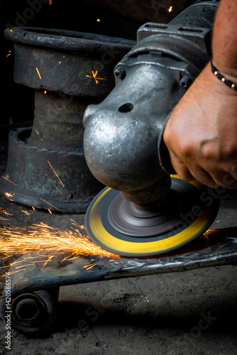Person working in industry welding iron parts 