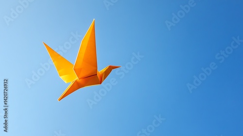 bright yellow origami bird soaring in a clear blue sky, capturing grace and simplicity