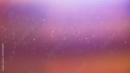 Stunning video background of dust particles swirling in rays of light. Iridescent and sparkling light particles glitter in the air flow. Magic of light