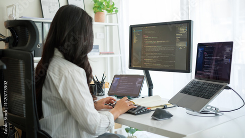 Focused female programmer coding at modern home office.