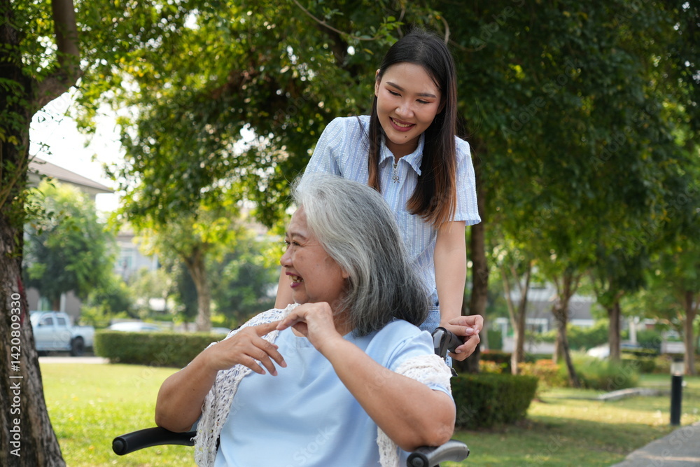 Two women, the daughter pushing a stroller with her elderly mother, walk in the garden and chat happily.