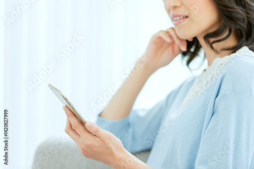 スマートフォンを見る中年女性