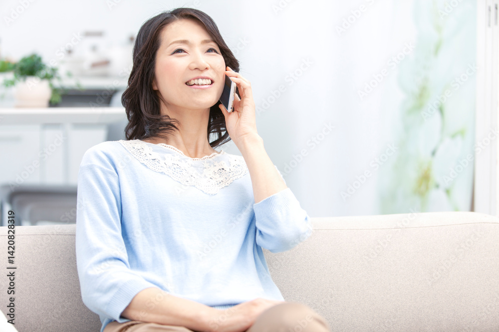 スマートフォンで電話する中年女性 スマートフォンで電話する中年女性
