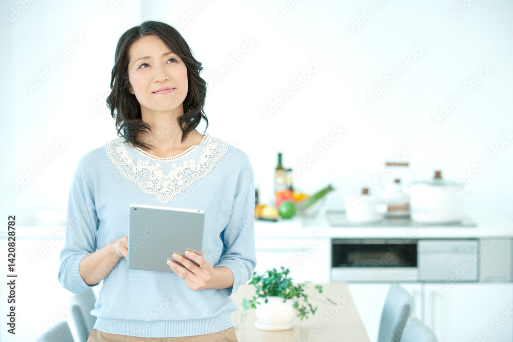 タブレットを操作する中年女性