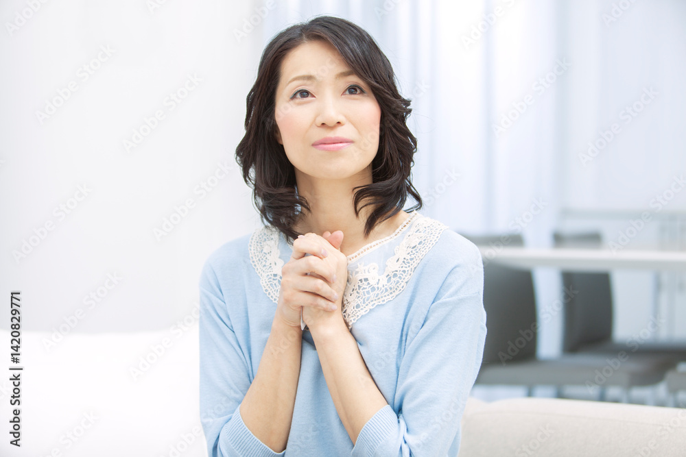 手を合わせて祈る中年女性