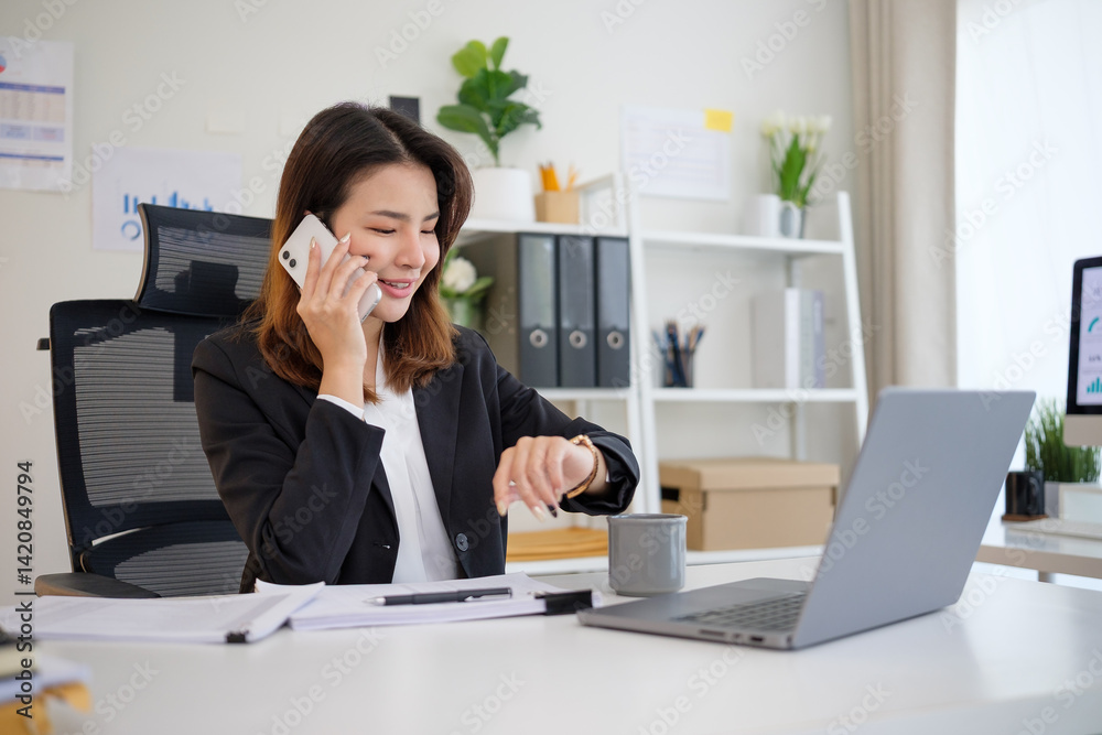 Confident businesswoman talking on mobile phone and checking the time on her wristwatch. Confident businesswoman talking on mobile phone and checking the time on her wristwatch.