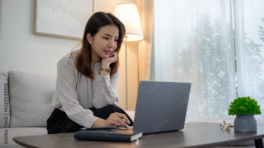 Beautiful asian woman using laptop on couch in bright living room. Beautiful asian woman using laptop on couch in bright living room.