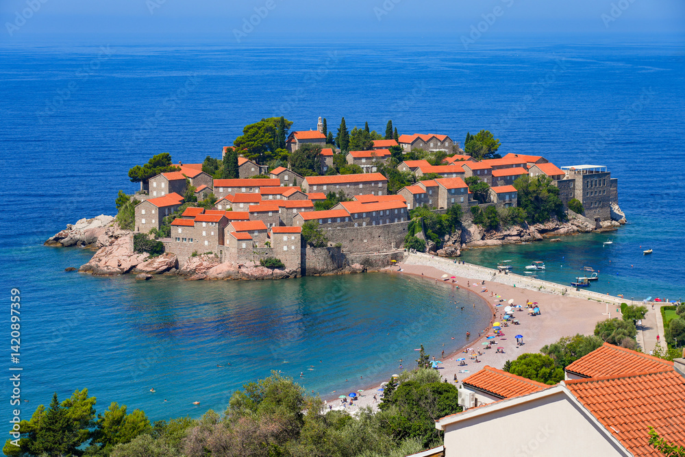 Aerial view of Sveti Stefan, a medieval village located on a small island connected to the mainland by a narrow tombolo (sandy isthmus) in the bay of Budva along the Adriatic Coast, Montenegro
