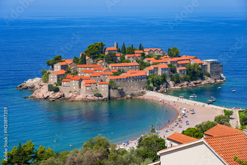 Aerial view of Sveti Stefan, a medieval village located on a small island connected to the mainland by a narrow tombolo (sandy isthmus) in the bay of Budva along the Adriatic Coast, Montenegro