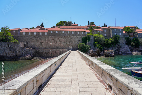 Walkway to Sveti Stefan, a medieval village located on a small island connected to the mainland by a narrow tombolo (sandy isthmus) in the bay of Budva along the Adriatic Coast, Montenegro