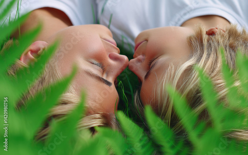 Lying on grass, couple shares intimate moment, surrounded by lush greenery, evoking feelings of love and connection