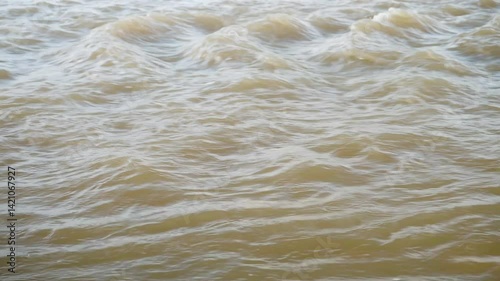 Turbid water flow. Rapid flow mountain river. Dirty stream flooding