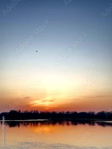 Sunset Sky with Clouds Reflected on Water Surface