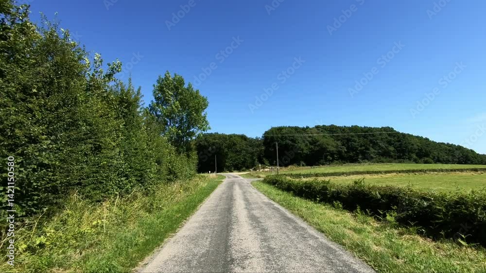 The greenway that winds through the green countryside in Europe, France, Burgundy, Nievre, towards Chateau Chinon, in summer, on a sunny day. The greenway that winds through the green countryside in Europe, France, Burgundy, Nievre, towards Chateau Chinon, in summer, on a sunny day.