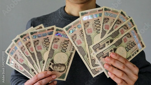 大量の一万円札を持つ人物