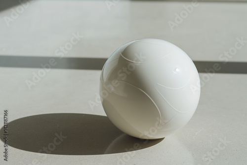 Minimalist white sphere on sunlit smooth surface with soft shadows