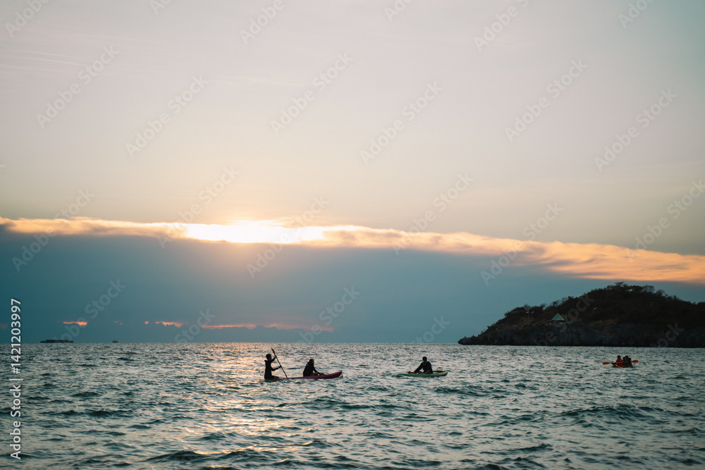 Fototapeta premium The island glowed beneath the summer sky as the sun set over the ocean, painting the seascape in warm hues—an unforgettable moment in a perfect travel escape.