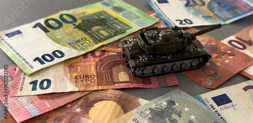 Obraz na płótnie Tank on background of banknotes. Currency war. War costs, military spending. Making money from war. Money laundering on War. Military economy. Military tank and European banknotes. Weapons trade. w salonie