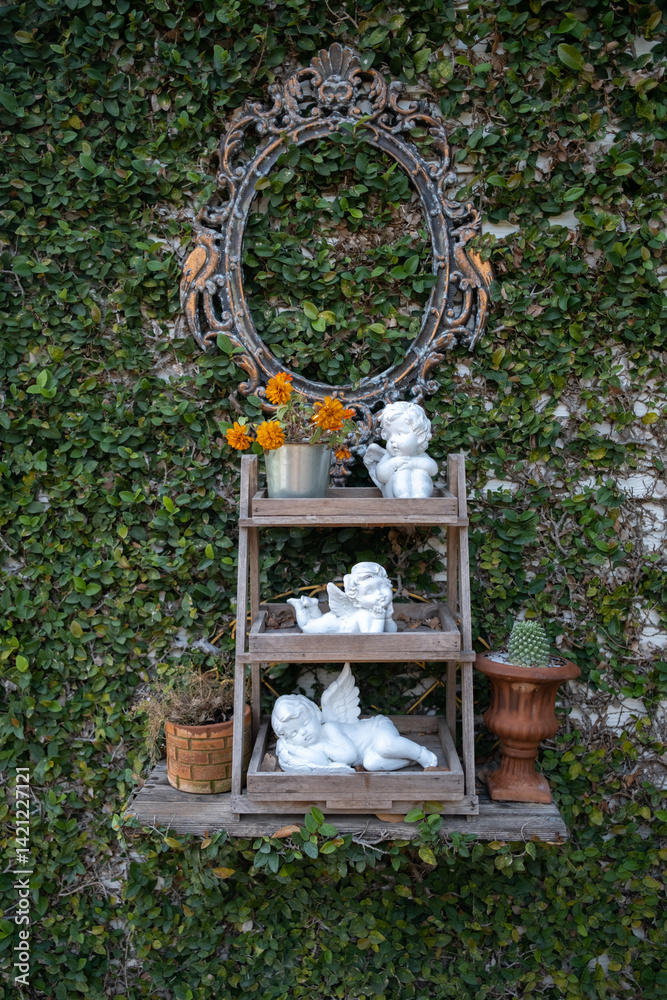 Cupid statue on the wooden shelf in the garden