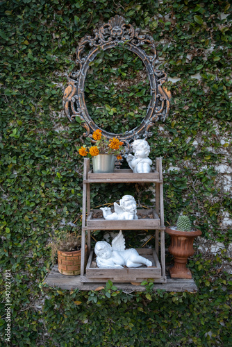 Obraz na płótnie Cupid statue on the wooden shelf in the garden w salonie