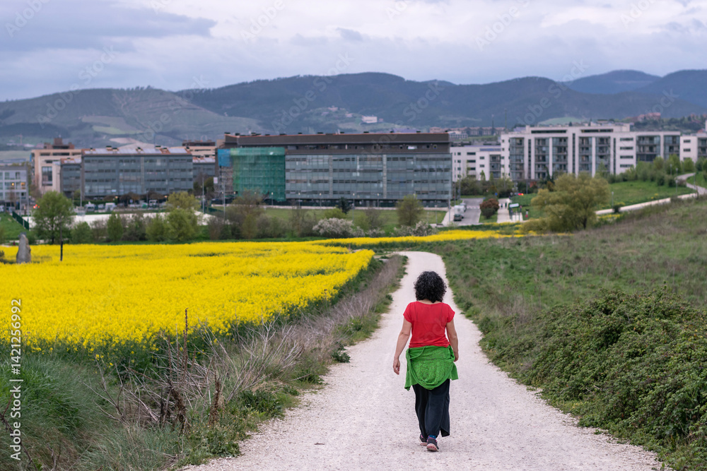 Fototapeta premium Woman walks home through fields. Sarriguren, Navarra