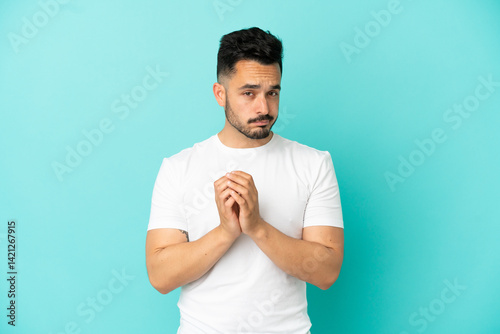 Young caucasian man isolated on blue background scheming something