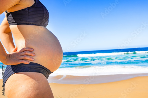 Frau mit Babybauch am Srand