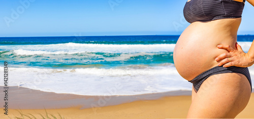 Frau mit Babybauch am Srand