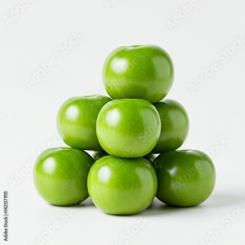 Fresh, vibrant green tomatillos arranged in a pyramid shape on a white background. photo