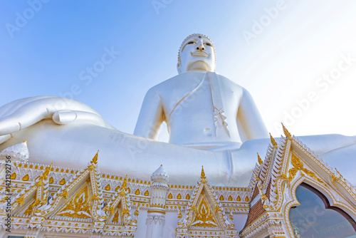 A large white Buddha statue stands at the center of the temple Wat Roi Phra Phutthabat Phu Manorom, is situated on Phu Manorom, a small mountain in,Mukdahan,Thailand photo