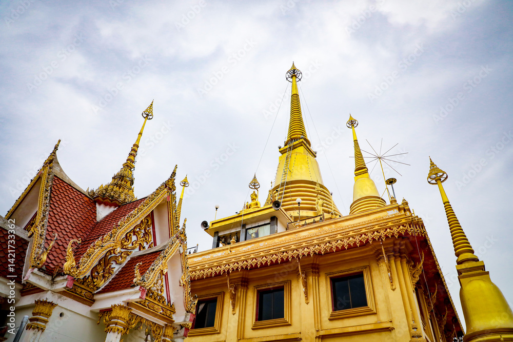 Fototapeta premium Wat Khiriwong, the highlight is the Ubosot and Phra Chulamani Chedi, located on the top of Khao Daowadueng, and offers a high angle view of Nakhon Sawan. It is a beautiful sunset viewing point.