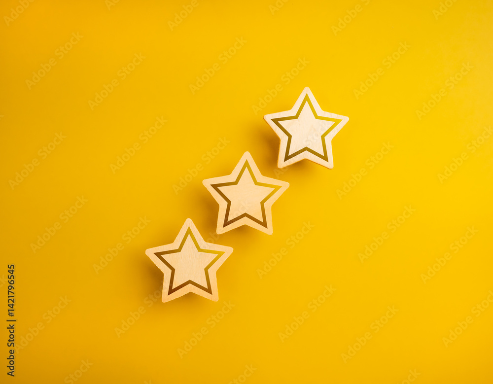 Obraz premium Shining three wooden stars ratings, isolated on yellow background, minimal style. High level of excellence quality or satisfaction, customer evaluation and review, business marketing concept.