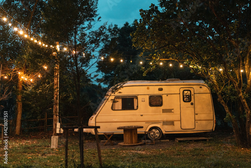 Cozy Camping Adventure in the Wilderness, Van Trailer Setup at Campground Surrounded by Nature, Enjoying Relaxing Night by the Campfire, Balefire in the Forest Landscape