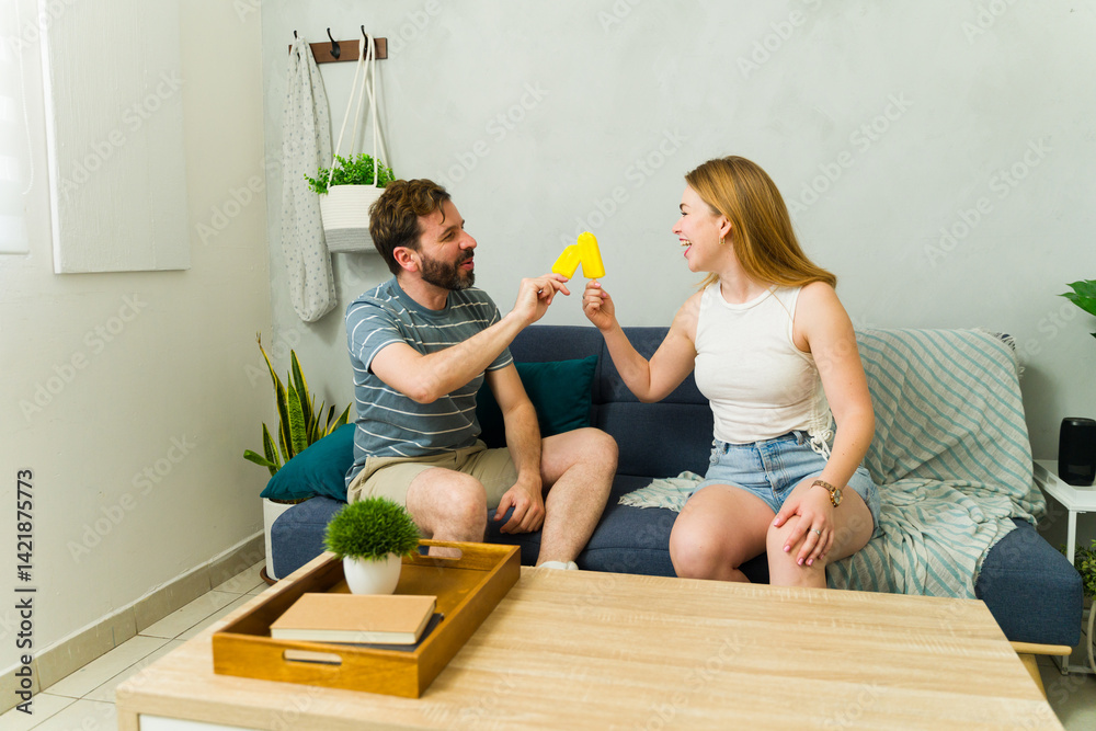 Couple sharing a popsicle at home during summer heat wave