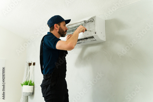 Obraz na płótnie Technician repairing air conditioning unit with screwdriver w salonie