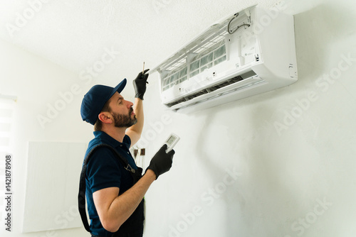 Obraz na płótnie Male technician installing or repairing air conditioning unit w salonie