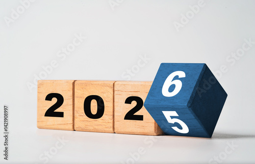 Flipping of 2025 to 2026 on wooden block cube for preparation new year change and start new business target strategy concept.