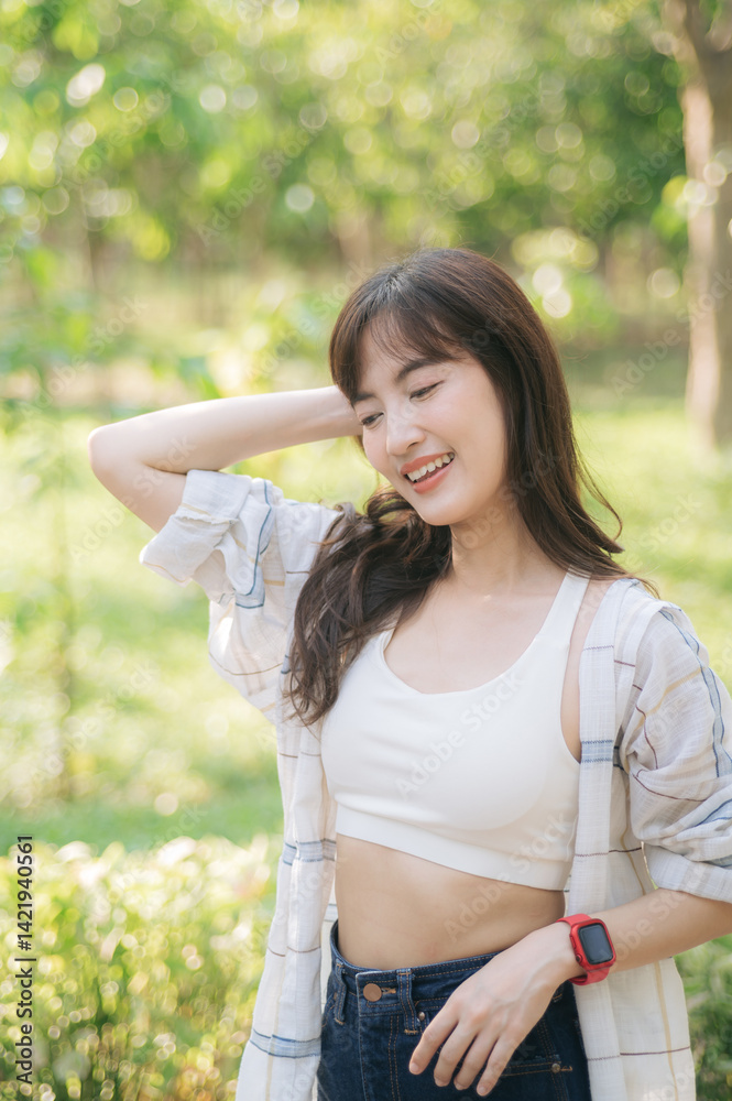 Asian woman enjoying summer outdoors, breathing fresh air with cheerful smile, wearing casual attire in lush green park Asian woman enjoying summer outdoors, breathing fresh air with cheerful smile, wearing casual attire in lush green park