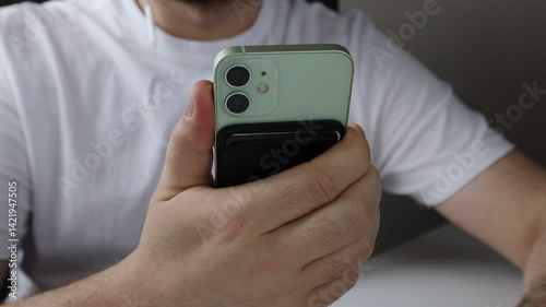 Person turns down the volume of a music while listening it on his phone