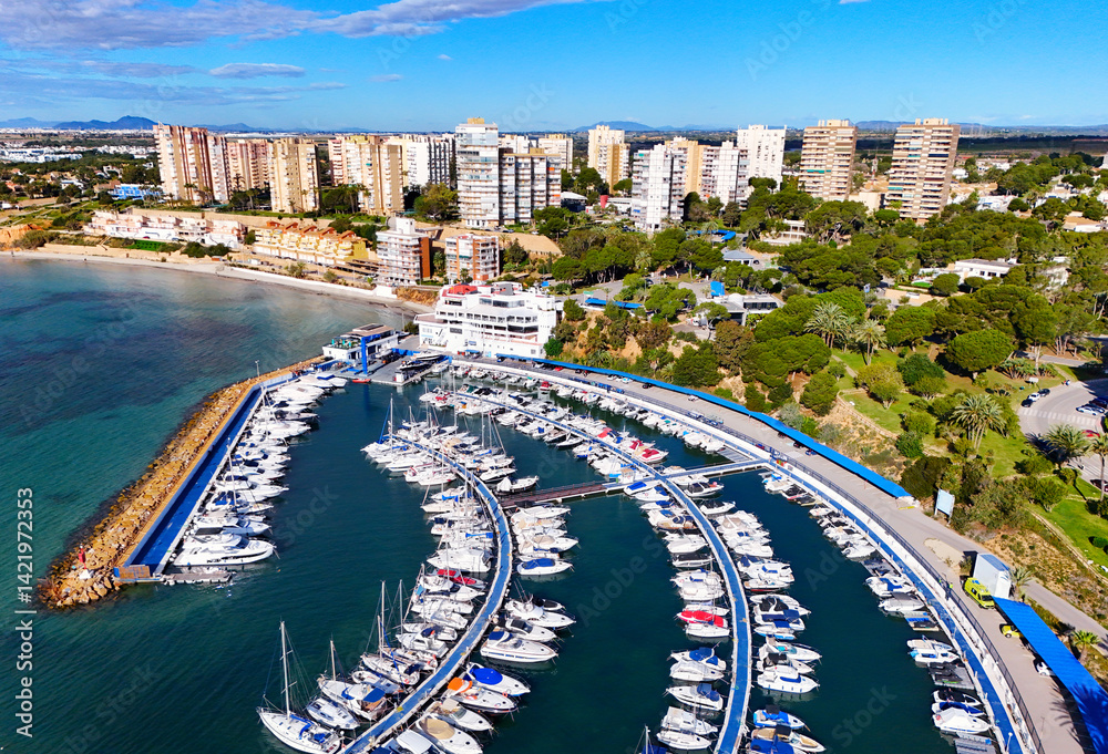 Aerial view of Dehesa de Campoamor resort town, with marina, residential houses and bay of Mediterranean Sea. Province of Alicante, Spain. Costa Blanca
