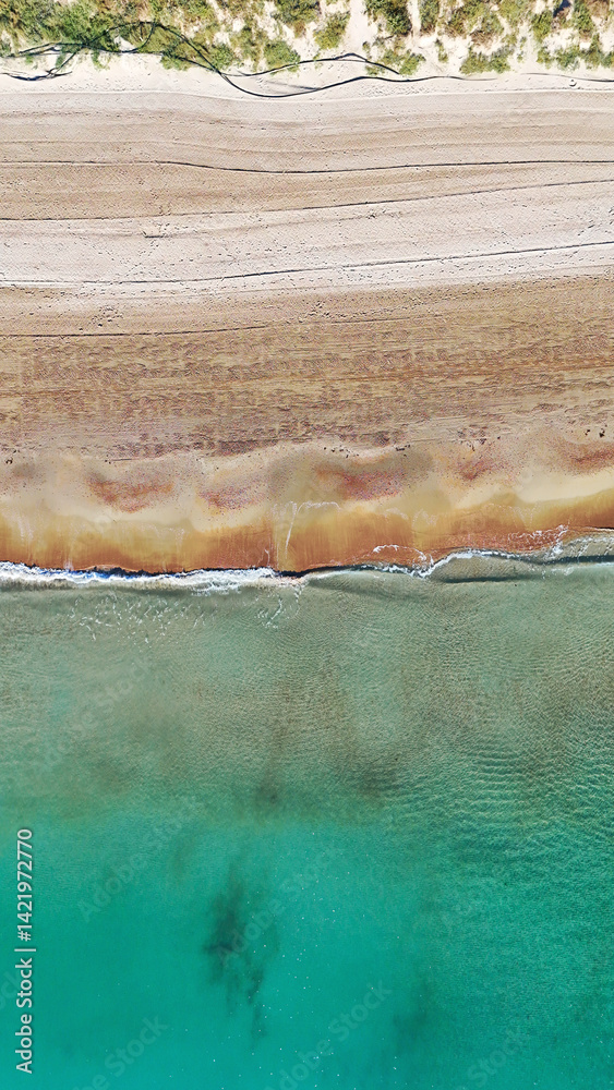 Aerial top view of sandy beach with clear turquoise water, soft waves, and layered sandy textures, untouched coastal beauty and natural patterns from above, no people. Cost Blanca, Spain