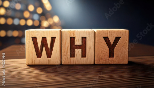 Wooden blocks spelling WHY on wooden surface with warm lighting