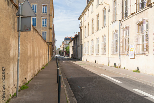 Quiet street in Nancy, France, known as Rue du Manège, with old stone buildings, soft shadows, and a peaceful urban atmosphere.